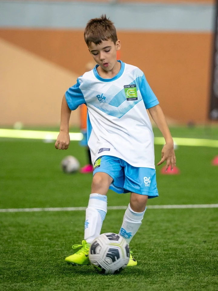 Zēns Coerver formā vada bumbu